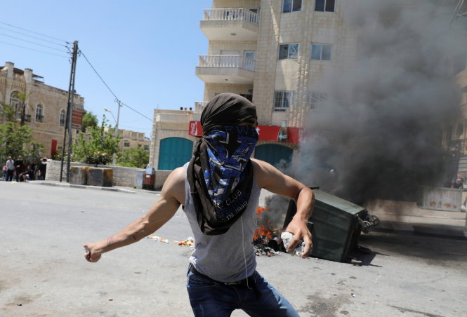 Người biểu tình ném đá về phía cảnh sát Israel trong cuộc xuống đường ngày 17-4 ở Bethlehem - Ảnh: Reuters