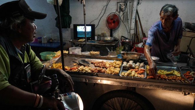 Một người bán thịt xiên tại quận Phrakanong ở thủ đô Bangkok - Ảnh: AFP