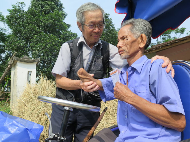 “Chúng tôi trao anh chút tiền này. Đây là số tiền trợ cấp thương binh hằng tháng. Mong anh mạnh khỏe, sống vui những tháng ngày còn lại” - ông Nguyễn Tiến Dân (trái) nói với ông Đỗ Văn Phẩm - Ảnh: TẤN VŨ