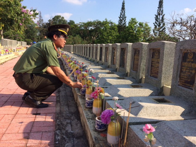 Thế hệ trẻ công an nhân dân thắp nhang tưởng nhớ các anh hùng liệt sĩ tại nghĩa trang Đồi 82 - Ảnh: M.PHƯỢNG