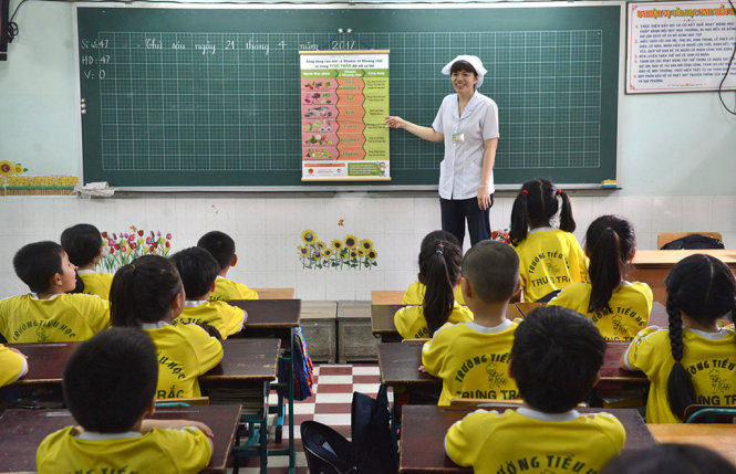 Cô giáo thuyết trình về chế độ dinh dưỡng cho các em học sinh - Ảnh: DUYÊN PHAN