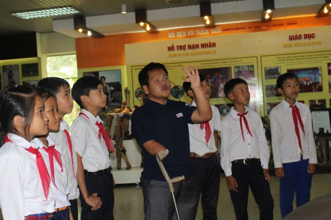 Anh Hồ Văn Lai giới thiệu cho học sinh Trường THCS Trung Giang cách nhận diện các loại bom mìn để phòng tránh - Ảnh: Đoàn Nhạn
