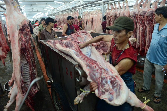 Mua bán thịt heo tại chợ đầu mối H.Hóc Môn, TP.HCM - Ảnh: Quang Định
