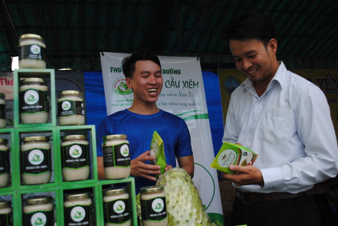 Đặng Quý Ngọc (trái) tiếp thị với khách hàng về sản phẩm của công ty tại hội chợ Hàng Việt về nông thôn ở Lai Vung - Ảnh: Thành Nhơn
