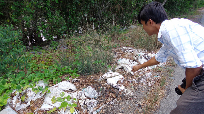 Các bao chất thải lạ nằm ven đường tỉnh 867 - Ảnh: HOÀI THƯƠNG