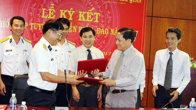 Đại tá Nguyễn Trọng Ái và ông Trần Văn Thông trao văn bản ký kết tuyên truyền biển đảo năm 2017