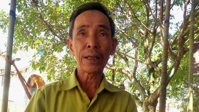 Ông Năm ngồi trước trụ sở HĐND tỉnh Quảng Trị chờ gửi đơn xin minh oan cho cha - Ảnh: Quốc Nam