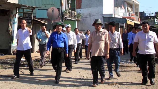Ông Hà (áo xanh giữa) nghe lãnh đạo tỉnh An Giang báo cáo tình hình sạt lở ở khu vực sông Hậu - Ảnh: Bửu Đấu