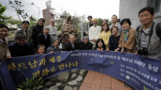Người tham dự chụp hình lưu niệm cùng tượng Pieta Việt Nam - Ảnh: Woohae Cho