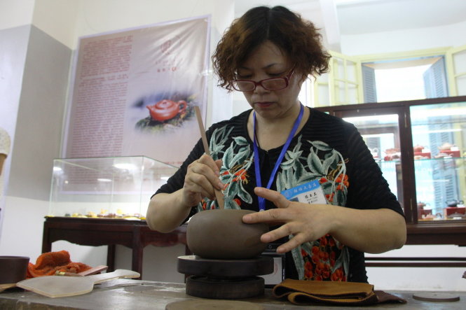 Một nghệ nhân Trung Quốc đang biểu diễn quá trình làm ra một sản phẩm gốm truyền thống - Ảnh: NHẬT LINH