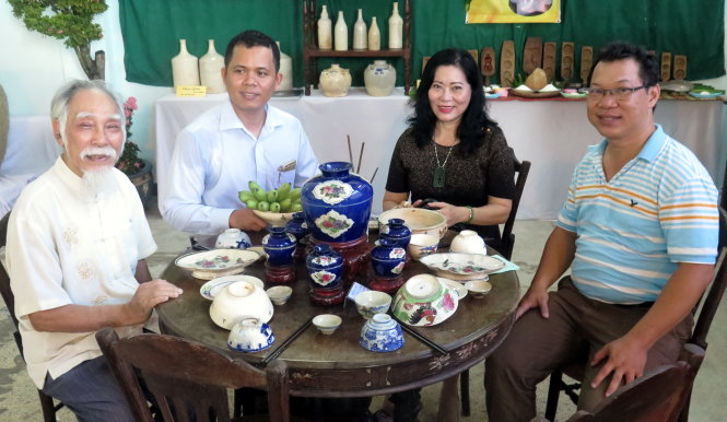 Họa sĩ Cát Mậu Lâm (bìa trái) cùng các nhà sưu tập bên góc trưng bày một bàn ăn gia đình truyền thống của Lái Thiêu - Ảnh: L.Điền