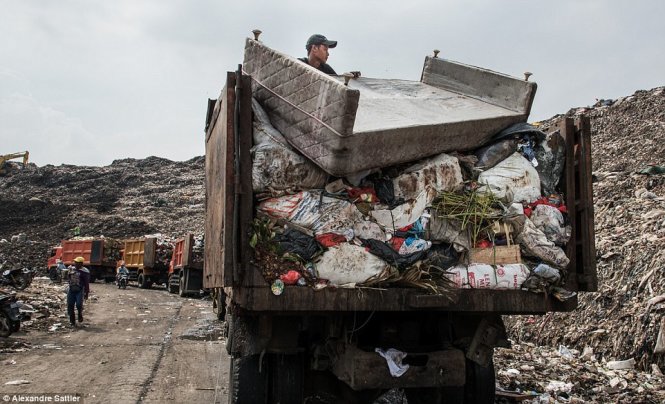 Những chiếc xe tải chở rác to đùng trở nên nhỏ bé trước núi rác khổng lồ