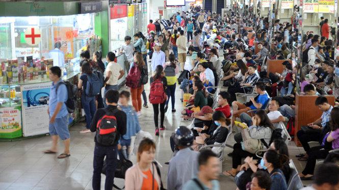 Bên trong Bến xe Miền Đông hàng trăm hành khách ngồi chờ - Ảnh: Lê Phan