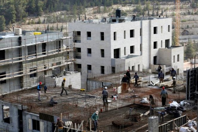 Các công nhân đang làm việc tại một công trường xây dựng nhà ở của Israel tại khu vực Bờ Tây - Ảnh: Reuters