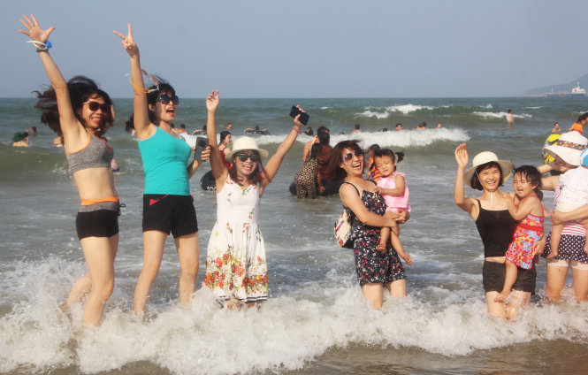 Một nhóm du khách đến từ Hà Nội đùa giỡn với sóng biển Cửa Lò, Nghệ An- Ảnh: Doãn Hòa