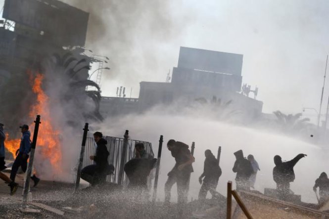 Người biểu tình đụng độ cảnh sát ở Santiago, Chile - Ảnh: REUTERS