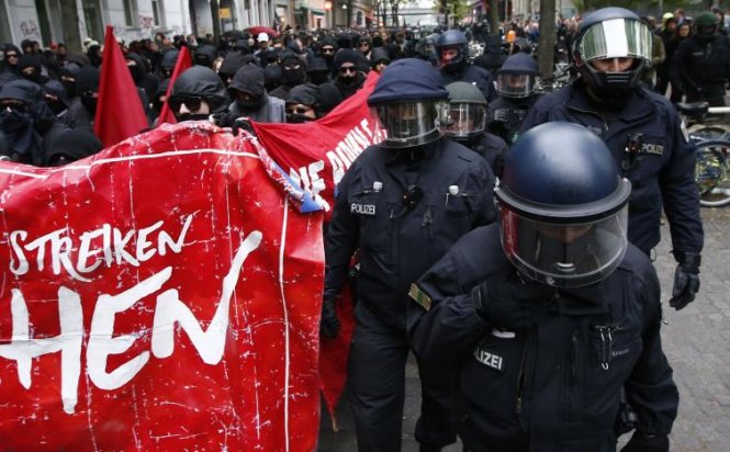Cảnh sát chống bạo động Đức canh giữ người biểu tình ở Berlin - Ảnh:  REUTERS