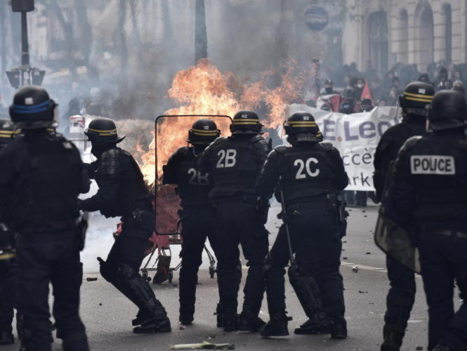 Người biểu tình tấn công cảnh sát ở Paris - Ảnh: AFP