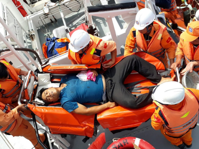 ngư dân Huỳnh Hoàng Ân được nhân viên cứu hộ, cứu nạn Hàng hải đưa về bờ cứu chữa- Ảnh: Vietnam MRCC