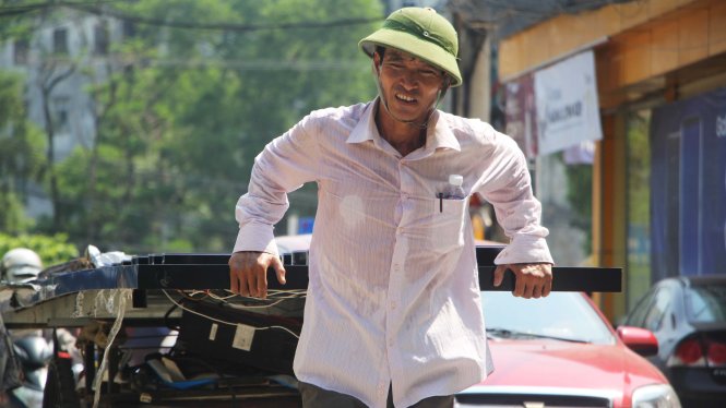 Một người đàn ông mệt mỏi kéo hàng trên đường Kim Đồng, TP Vinh trưa 3-5 - Ảnh: Doãn Hòa