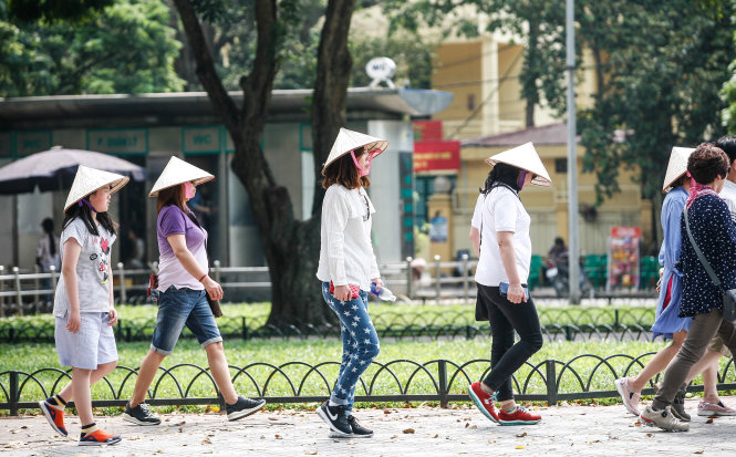 Khách du lịch nước ngoài dùng nón để đội tránh nắng - Ảnh: NAM TRẦN