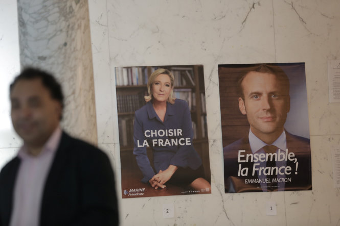 Ảnh của hai ứng viên tổng thống Pháp Marine Le Pen (trái) và Emmanuel Macron (phải) tại điểm bỏ phiếu thuộc Tổng lãnh sự Pháp ở thành phố New York (Mỹ) ngày 6-5 - Ảnh: Reuters
