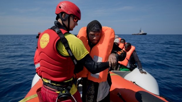 Nhân viên của Proactiva Open Arms đang giúp một người tị nạn được cứu trên Địa Trung Hải hôm 6-4-2017 - Ảnh: AP