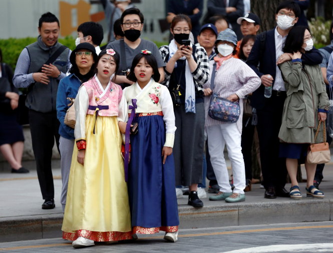 Pedestrians watch an election campaign rally of Moon Jae-in, the presidential candidate of the Democratic Party of Korea, in Seoul, South Korea May 8