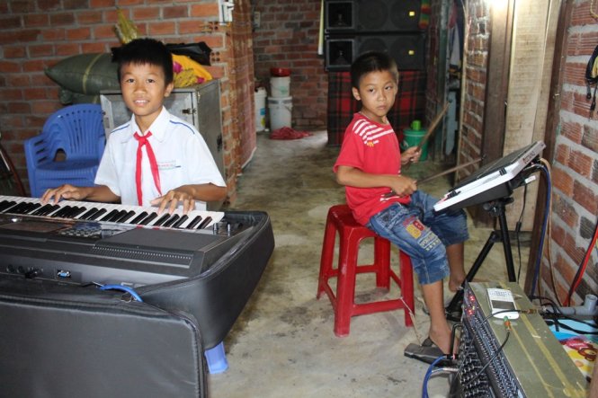 Với bộ trống, cây đàn, hai anh em Bảo và Phong mang hạnh phúc đến với mẹ cha - Ảnh: T.Thịnh