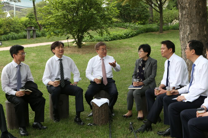 Tân Tổng thống Moon Jae In (thứ ba từ trái qua) cùng dàn cố vấn của mình ngồi thoải mái thảo luận trong sân vườn Nhà Xanh ngày 11-5 - Ảnh: Reuters