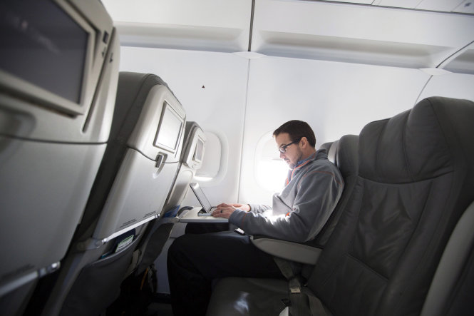 Hành khách sử dụng máy tính trên một chuyến bay ở Mỹ - ảnh: Reuters