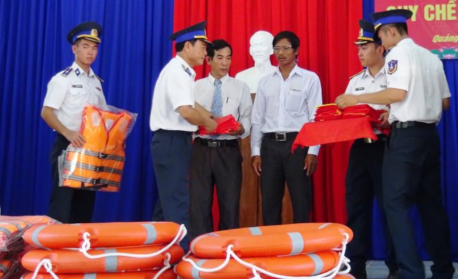 Cảnh sát biển tặng cờ Tổ quốc, phao cứu sinh cho ngư dân - Ảnh: Lê Trung