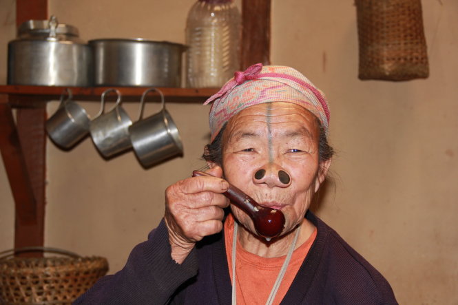 Bà lão Millo Yaza với chiếc mũi kỳ dị đang uống rượu được ủ từ lúa rẫy -
 Ảnh: TRẦN MAI
