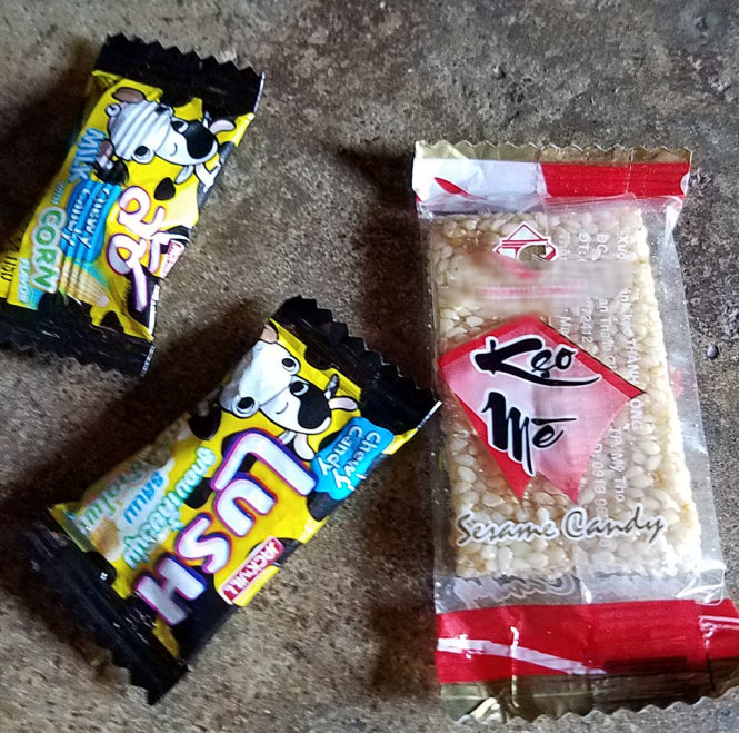 Một trong nhiều loại kẹo mà các em học sinh ở xã Ea Uy nhận từ người lạ tới cổng trường học phát - Ảnh: B.D