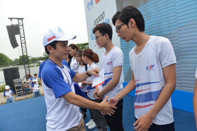 Ông Trần Xuân Toàn (phải) - Ủy viên ban biên tập báo Báo Tuổi Trẻ, trao học bổng cho các bạn sinh viên tại chương trình - Ảnh: Duyên Phan