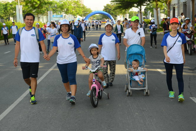 Gia đình anh chị Nguyên Khánh - Bích Liên và bé Nguyên Khang, cùng gia đình anh Huỳnh Văn Phát - Ái Hoa và bé Trường Kim (4 tuổi) đi bộ trong chương trình - Ảnh: Quang Định