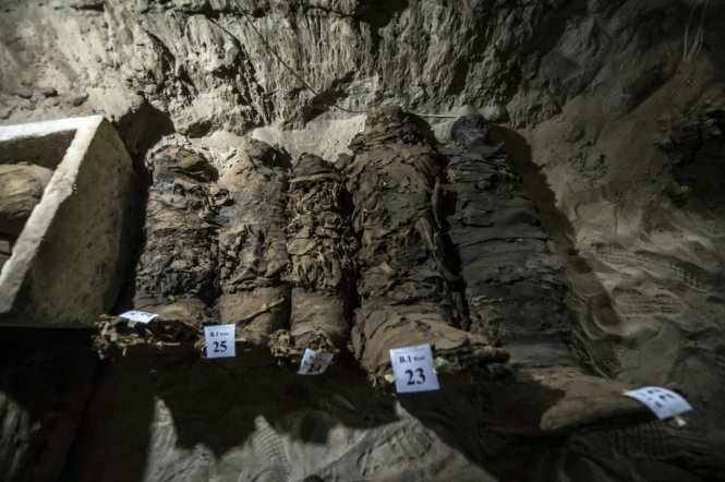 Các xác ướp bọc bằng vải lanh cạnh xác ướp nằm trong quách (trái) - Ảnh: AFP