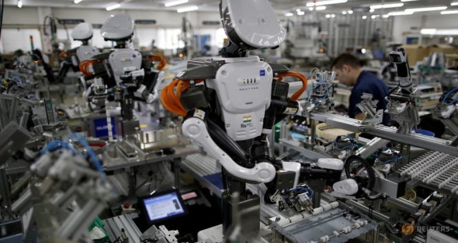 Robot cùng làm việc với nhân viên trong dân chuyền lắp ráp tại một nhà máy của công ty Glory ở phía bắc Tokyo, Nhật - Ảnh: Reuters