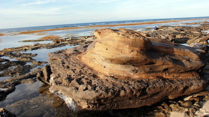 Một tảng đá núi lửa trông như thạch nhũ nằm trơ trọi giữa bãi biển - Ảnh: Trần Mai