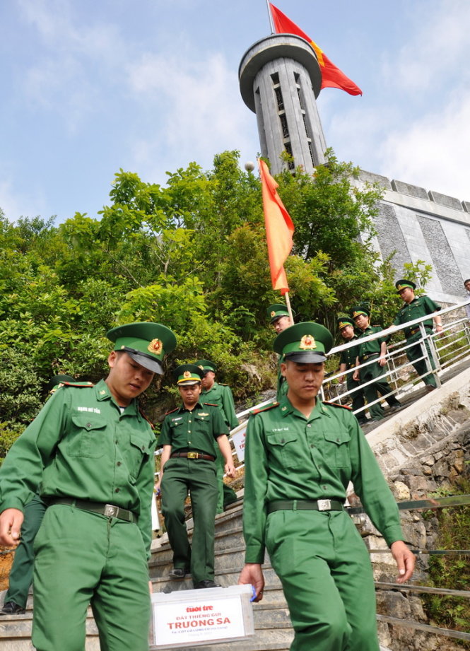 Những người lính Đồn biên phòng Lũng Cú, Hà Giang mang đất thiêng từ cột cờ trao cho báo Tuổi Trẻ - Ảnh: Ngọc Quang