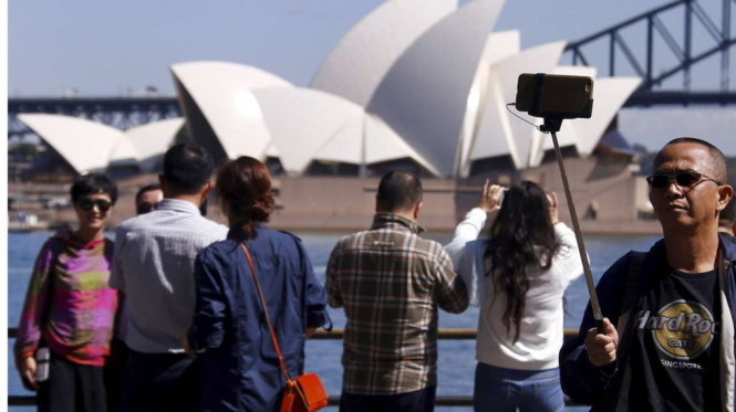 Khách du lịch Trung Quốc đứng trước nhà hát Opera ở Sydney (Úc) - Ảnh: Reuters