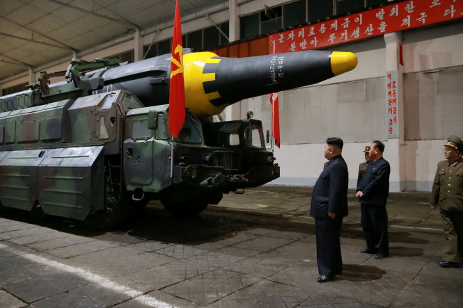 Lãnh đạo Triều Tiên Kim Jong Un (trái) đi kiểm tra tên lửa Hwasong-12 được cho là đã phóng thành công hôm 14-5 - Ảnh: Reuters