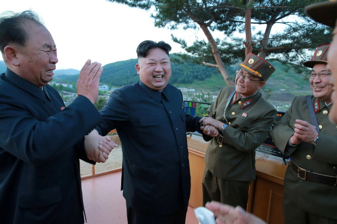 Lãnh đạo Triều Tiên Kim Jong Un (giữa) hoan hỉ cùng các nhà khoa học và tướng lĩnh quân đội sau khi thử tên lửa thành công hôm 14-5 - Ảnh: Reuters