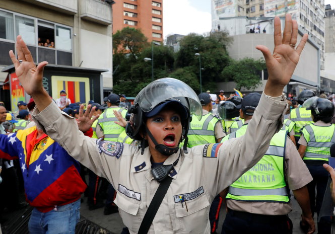 A police officer tries to calm the people down as elderly opposition supporters rally against President Nicolas Maduro in Caracas, Venezuela, May 12