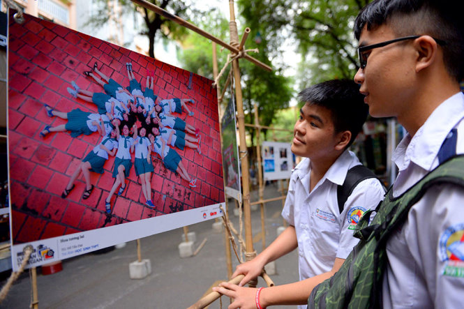 Học sinh phấn khởi khi xem ảnh sắp triễn lãm tại đường sách Nguyễn Văn Bình - Ảnh: HỮU KHOA