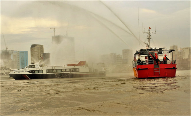 Tiếp cận dập lửa cứu người, đưa tàu vào bờ - Ảnh: TÂM ĐỨC
