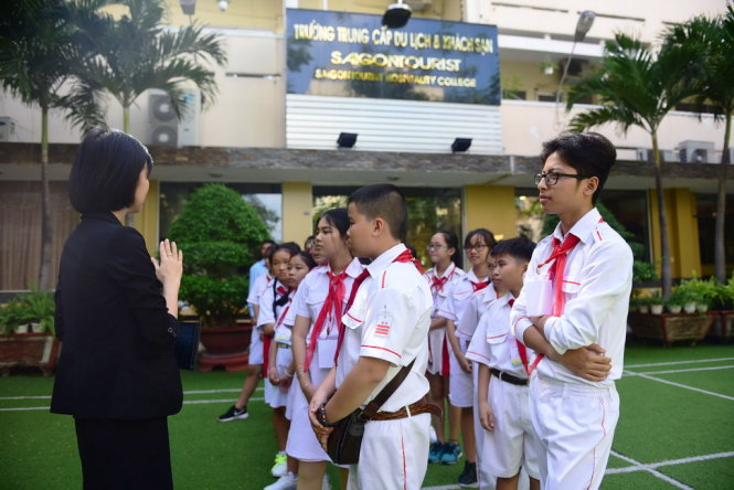 Hướng dẫn viên giới thiệu cho các em về các ngành học của trừng Saigon Tourist - Ảnh: HỮU THUẬN