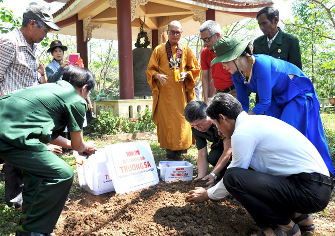 Những người cựu binh, người dân Vân Kiều cùng các phật tử đi hành hương lấy đất ở nghĩa trang liệt sĩ Trường Sơn để gửi ra Trường Sa - Ảnh: TẠ THÀNH ĐẠT