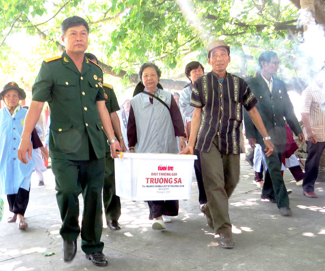 Chủ tịch Hội cựu chiến binh huyện Gio Linh Hoàng Liên Sơn (trái) và già làng Hồ Văn Vê mang “Đất thiêng gửi Trường Sa” - Ảnh: TẠ THÀNH ĐẠT