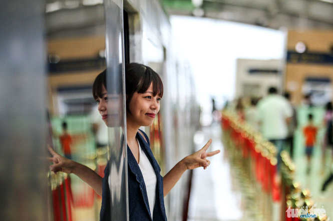 Một cô gái chụp ảnh lưu niệm tại cửa ra vào của tàu, đoàn tàu được thiết kế theo quy phạm của Metro của Trung Quốc - Ảnh: NGUYỄN KHÁNH
